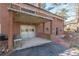 Brick home featuring a large garage, balcony, and brick patio and walkway in a wooded backyard at 407 North Ave, Atlanta, GA 30354