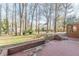 View of cracked brick patio and lawn with trees and house featuring brick carport in the distance at 407 North Ave, Atlanta, GA 30354