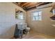 Unfinished basement bathroom with cinder block walls, pedestal sink, and toilet near a window at 407 North Ave, Atlanta, GA 30354