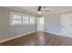 A bright bedroom with hardwood floors, neutral paint, a ceiling fan, and a doorway leading to a bathroom at 407 North Ave, Atlanta, GA 30354