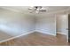 A cozy bedroom with hardwood floors, neutral paint, a ceiling fan, and a doorway leading to another room at 407 North Ave, Atlanta, GA 30354