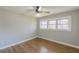 A bedroom featuring hardwood floors, neutral paint, a ceiling fan, and a large window offering natural light at 407 North Ave, Atlanta, GA 30354