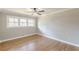 A bright bedroom featuring hardwood floors, neutral paint, a ceiling fan, and large windows offering abundant natural light at 407 North Ave, Atlanta, GA 30354