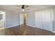 A bedroom featuring hardwood floors, neutral paint, a ceiling fan, a bathroom and a closet with sliding doors at 407 North Ave, Atlanta, GA 30354