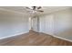 A spacious bedroom with hardwood floors, neutral paint, a ceiling fan, and closet with sliding doors at 407 North Ave, Atlanta, GA 30354
