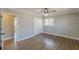 A bright bedroom with hardwood floors, neutral paint, a ceiling fan, and a doorway leading to another room at 407 North Ave, Atlanta, GA 30354