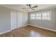 A bedroom featuring hardwood floors, neutral paint, a ceiling fan, and a large window offering natural light at 407 North Ave, Atlanta, GA 30354