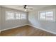 A bright bedroom featuring hardwood floors, neutral paint, a ceiling fan, and large windows offering abundant natural light at 407 North Ave, Atlanta, GA 30354