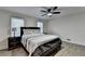 Bedroom with wood floors features a ceiling fan, bedside lamps, and bright natural light at 4087 Signal Rdg, Lilburn, GA 30047