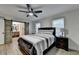 Bedroom with wood floors features a ceiling fan, bedside lamps, and a sliding barn door at 4087 Signal Rdg, Lilburn, GA 30047