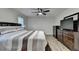 Bedroom with wood floors features a ceiling fan, TV, and a spacious dresser at 4087 Signal Rdg, Lilburn, GA 30047