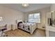 Bright bedroom featuring hardwood floors, a large window, a full-sized bed, and dresser with TV at 4087 Signal Rdg, Lilburn, GA 30047