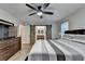 Bedroom with wood floors features a ceiling fan, TV, a dresser, and a sliding barn door at 4087 Signal Rdg, Lilburn, GA 30047