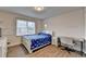 Bright bedroom featuring hardwood floors, a large window, a full-sized bed, and desk for studying at 4087 Signal Rdg, Lilburn, GA 30047