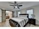 Bedroom with wood floors features a ceiling fan, bedside lamps, and a sliding barn door at 4087 Signal Rdg, Lilburn, GA 30047