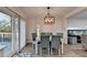 Bright dining room featuring a modern chandelier, seating for six, and sliding glass doors leading to a deck at 4087 Signal Rdg, Lilburn, GA 30047