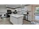 Modern, bright kitchen with a large island, white cabinets, stainless steel appliances, and access to the deck at 4087 Signal Rdg, Lilburn, GA 30047