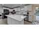 This open-concept kitchen has an island, white cabinets, stainless steel appliances, and access to outdoor deck at 4087 Signal Rdg, Lilburn, GA 30047