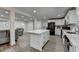 The kitchen opens to a living area with a kitchen island, stainless appliances, and all-white design at 4087 Signal Rdg, Lilburn, GA 30047