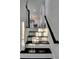 Stylish staircase with black treads and white risers leads to the main living area at 4087 Signal Rdg, Lilburn, GA 30047