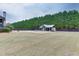 Large backyard highlighting a pool, poolhouse, and mature trees, creating a peaceful oasis for outdoor living at 1698 Little Fox Ln, Dacula, GA 30019