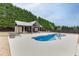An in-ground pool with a tanning ledge and a pool house are situated in a backyard setting at 1698 Little Fox Ln, Dacula, GA 30019
