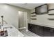Basement kitchenette and bar boasts granite countertops, dark cabinets, and ample storage space at 1698 Little Fox Ln, Dacula, GA 30019