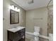 Bathroom featuring a dark wood vanity, framed mirror, toilet, and a tiled shower at 1698 Little Fox Ln, Dacula, GA 30019