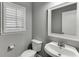 Half bath featuring a pedestal sink and a shuttered window at 1698 Little Fox Ln, Dacula, GA 30019