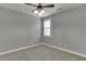 Cozy bedroom featuring plush carpet, a ceiling fan, and natural light from the window at 1698 Little Fox Ln, Dacula, GA 30019