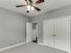 Inviting bedroom featuring a ceiling fan, neutral carpet, and closet doors at 1698 Little Fox Ln, Dacula, GA 30019