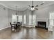 Open-concept dining room featuring a fireplace, large windows with shutters, and dark hardwood floors at 1698 Little Fox Ln, Dacula, GA 30019