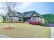 Inviting two-story home featuring brick accents, a well-kept lawn, and charming landscaping in a serene setting at 1698 Little Fox Ln, Dacula, GA 30019