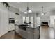 Modern kitchen island with black sink, cabinets, and view to the dining and living room at 1698 Little Fox Ln, Dacula, GA 30019