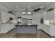 Elegant kitchen with a large island, white cabinetry, stainless steel appliances, and dark hardwood flooring at 1698 Little Fox Ln, Dacula, GA 30019