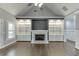 Open-concept living room with a fireplace, custom built-ins, and vaulted ceiling at 1698 Little Fox Ln, Dacula, GA 30019