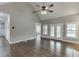 Bright living room featuring hardwood floors, a ceiling fan, and large windows with white shutters at 1698 Little Fox Ln, Dacula, GA 30019