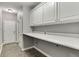 Well-organized mudroom with white cabinets, a countertop, and neutral tile flooring at 1698 Little Fox Ln, Dacula, GA 30019