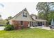 Back exterior view showing brick and siding details, screened porch, patio, and well-maintained yard at 5581 Stapleton Dr, Dunwoody, GA 30338