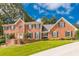 Beautiful brick home featuring a lush front yard and a symmetrical design with vibrant green shutters at 5581 Stapleton Dr, Dunwoody, GA 30338