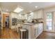 Well-lit kitchen features stainless steel appliances, custom cabinets, island, and hardwood floors at 5581 Stapleton Dr, Dunwoody, GA 30338