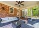 Inviting screened porch with brick accent wall, cozy seating, and a ceiling fan for comfortable outdoor living at 5581 Stapleton Dr, Dunwoody, GA 30338