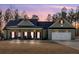 Charming single-story home featuring a covered porch, a two-car garage, and manicured lawn at dusk at 598 Barnwood Dr, Rockmart, GA 30153