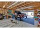 View inside garage with an auto on lift, workbench, lighting and open rafters at 598 Barnwood Dr, Rockmart, GA 30153