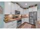 This kitchen features white cabinets, stainless steel appliances, and granite countertops at 598 Barnwood Dr, Rockmart, GA 30153