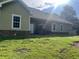 Exterior back of the home with green siding and a well maintained lawn at 10390 Rivertown Rd, Fairburn, GA 30213