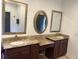 Bathroom boasts double vanities with granite counters, dark cabinets, and large framed mirrors at 10390 Rivertown Rd, Fairburn, GA 30213