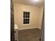 Bright bedroom with a window, hardwood floors, and white trim, providing a simple and inviting space at 10390 Rivertown Rd, Fairburn, GA 30213