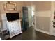 Bedroom with hardwood floors and a white dresser, offering a simple and versatile space at 10390 Rivertown Rd, Fairburn, GA 30213