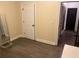 A bedroom with hardwood floors, white trim and door, and a mirror, offering a clean and versatile space at 10390 Rivertown Rd, Fairburn, GA 30213